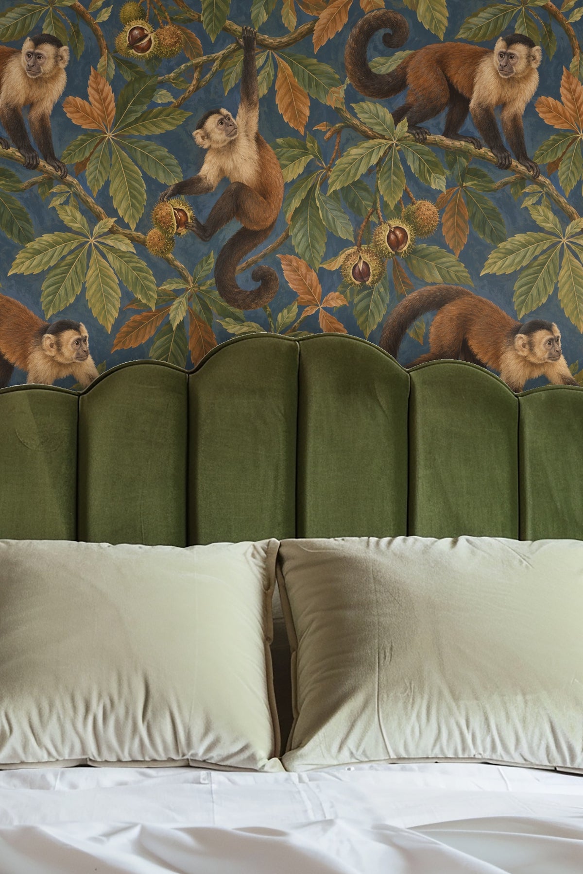 Entryway niche wallpapered with capuchin pattern around round mirror above wooden bench.