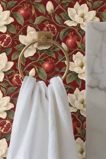 Wallpaper pattern with cream magnolia flowers, red pomegranates, and green leaves on a garnet red background.