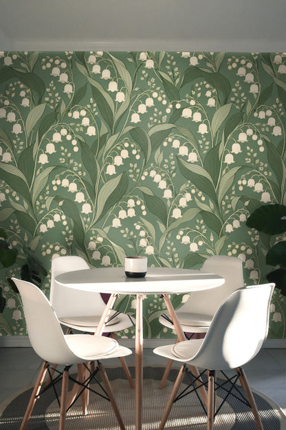 Pair of ivory pillows resting against green velvet headboard in floral wallpaper room