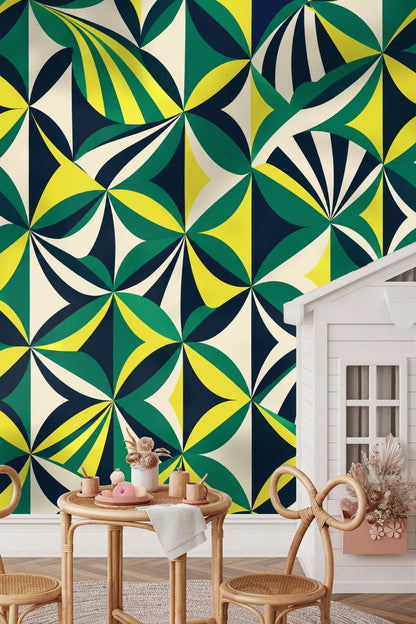 Bedroom scene with Emerald Compass Geometry wallpaper behind rattan bed and dark green cushions.