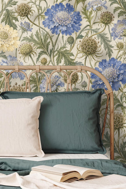 Close-up vignette of scabious seed wallpaper behind a wooden console adorned with ceramic vase and foliage