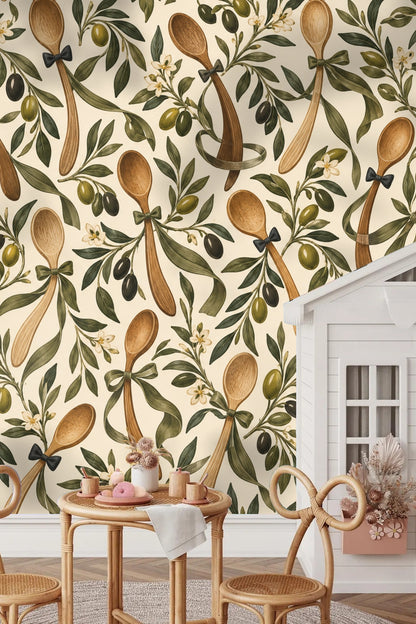 Wallpaper pattern detail showing wooden spoons with black bow ties among olive branches with black and green olives on cream background.