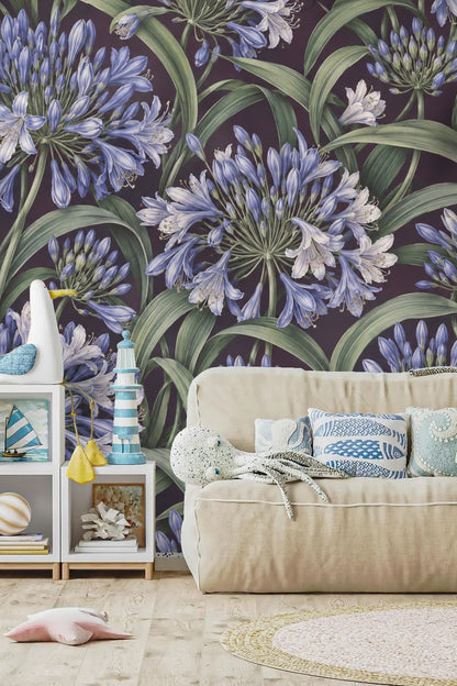 Photo of bedroom bed with pillows and agapanthus wallpaper wall behind, emphasizing color harmony.