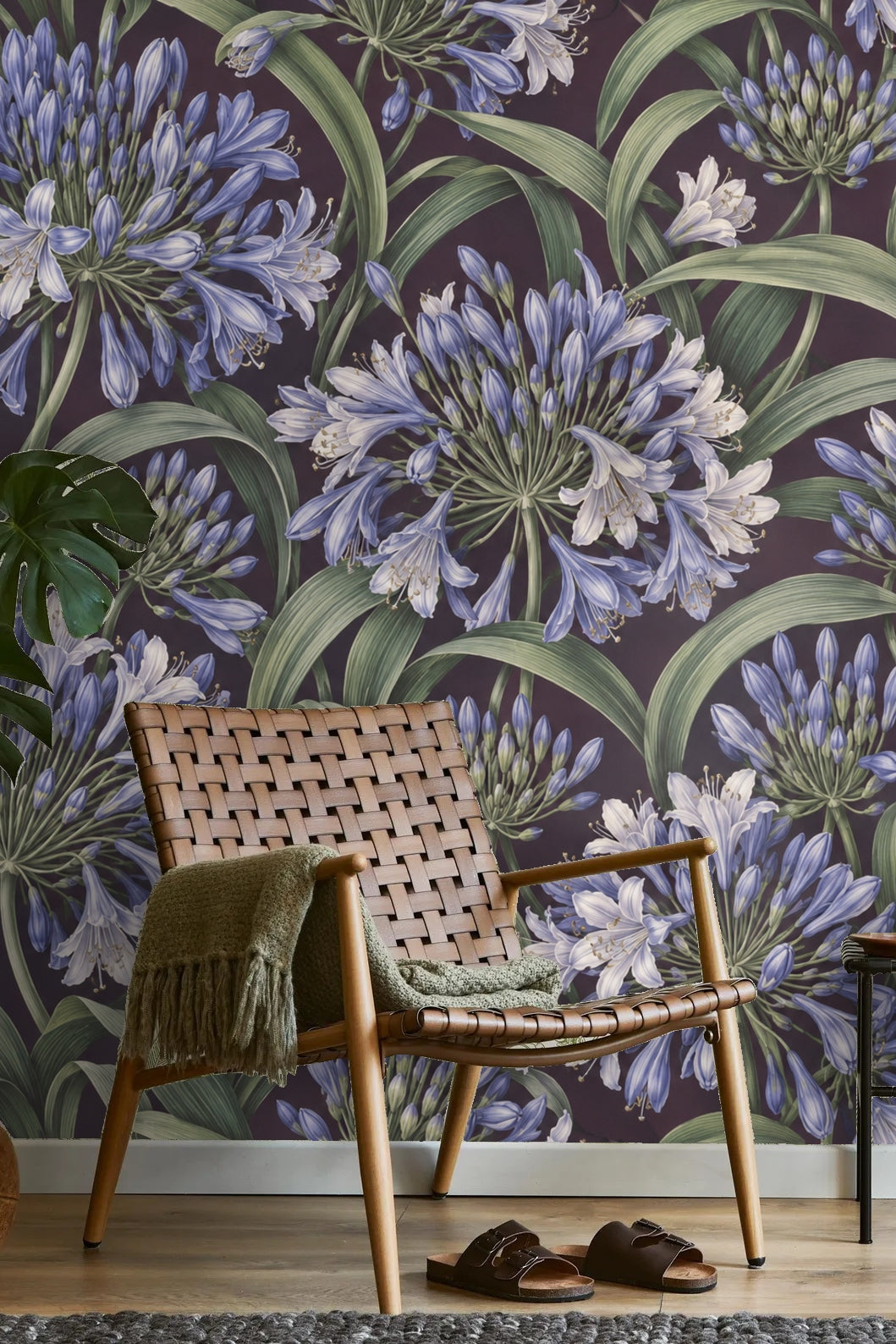 Artistic close-up of the purple background contrasting with the green leaves in Agapanthus Rainwheel wallpaper.