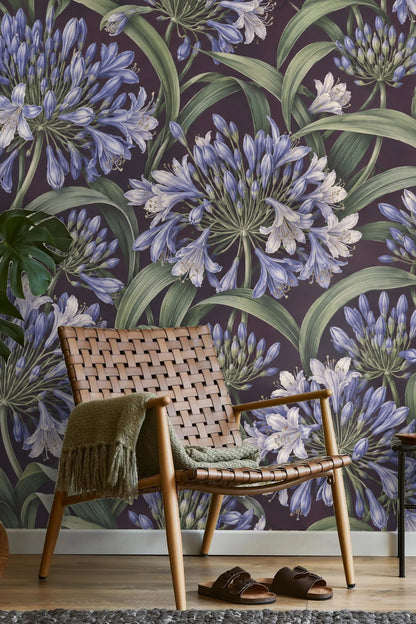 Artistic close-up of the purple background contrasting with the green leaves in Agapanthus Rainwheel wallpaper.