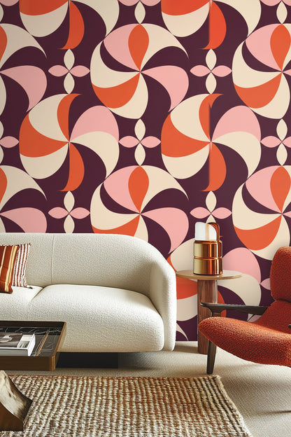 Bedroom wall behind green velvet headboard adorned with Plum Pinwheel wallpaper pattern