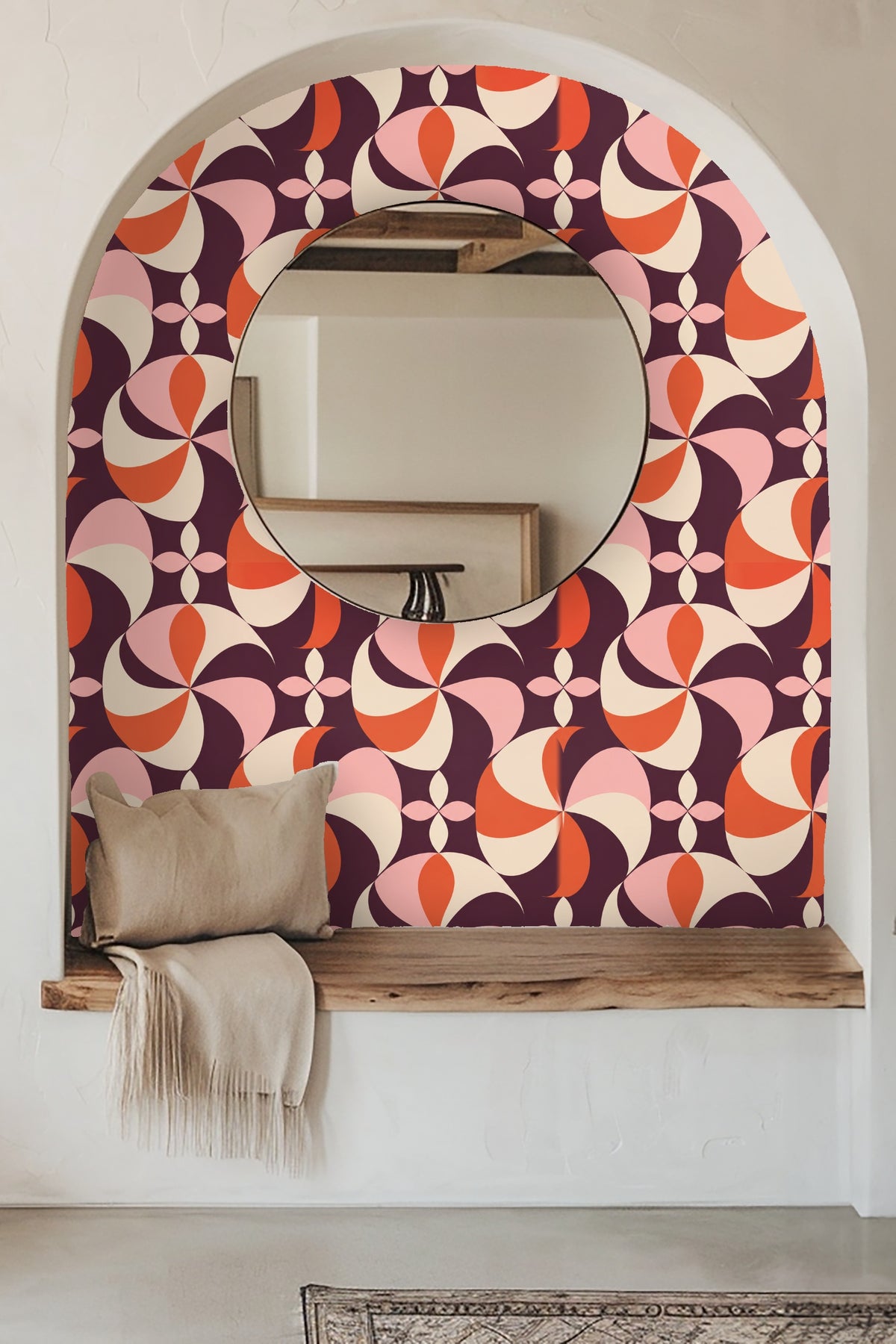 Close-up of Plum Pinwheel wallpaper pattern showing coral, plum, pink, and cream swirling shapes