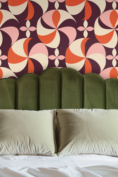 Entryway niche with arched wall covered in Plum Pinwheel wallpaper behind round mirror and wooden bench