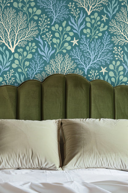 Living room with tan sofa against wallpaper of coral and seaweed in blue and green shades