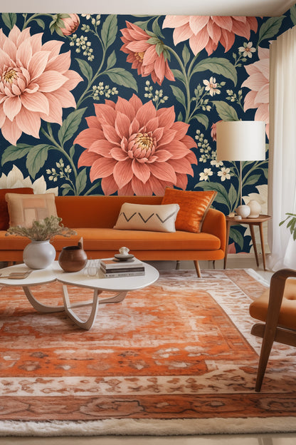Close-up of large coral and cream dahlia flowers with green leaves on deep navy background.