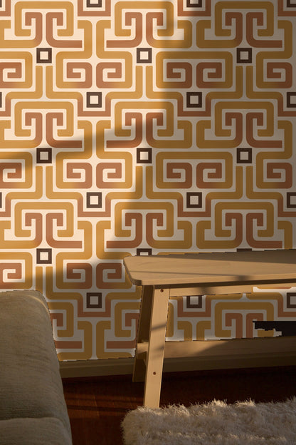 Bedroom interior with ochre meander wallpaper behind plush green headboard