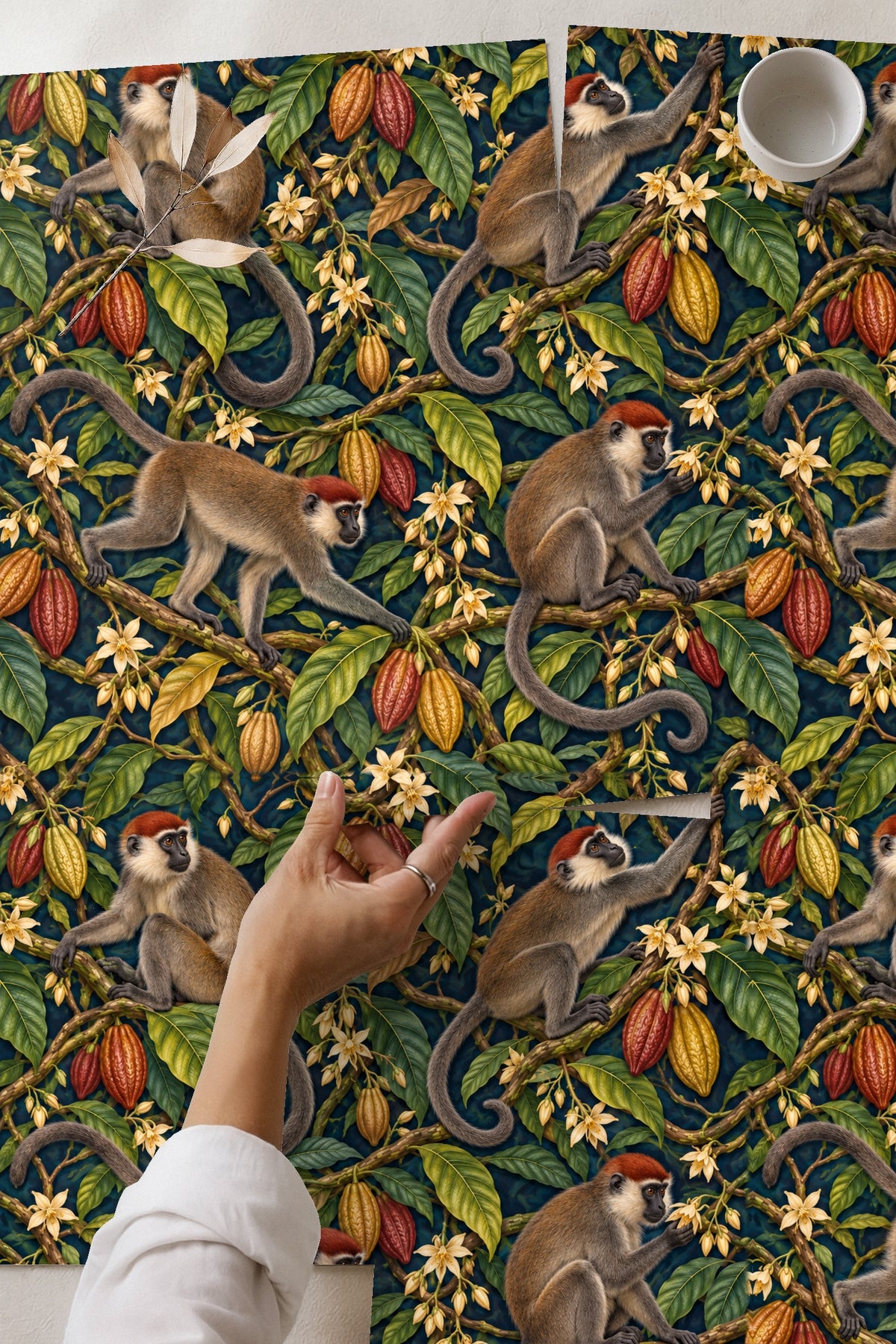 Interior view of blush pink scalloped chair beside wallpaper with monkeys on cocoa branches