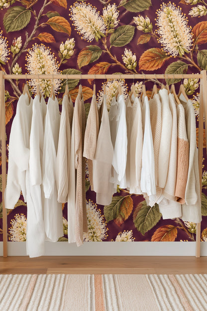 Textured leaves and detailed florals on plum background in botanical repeat pattern
