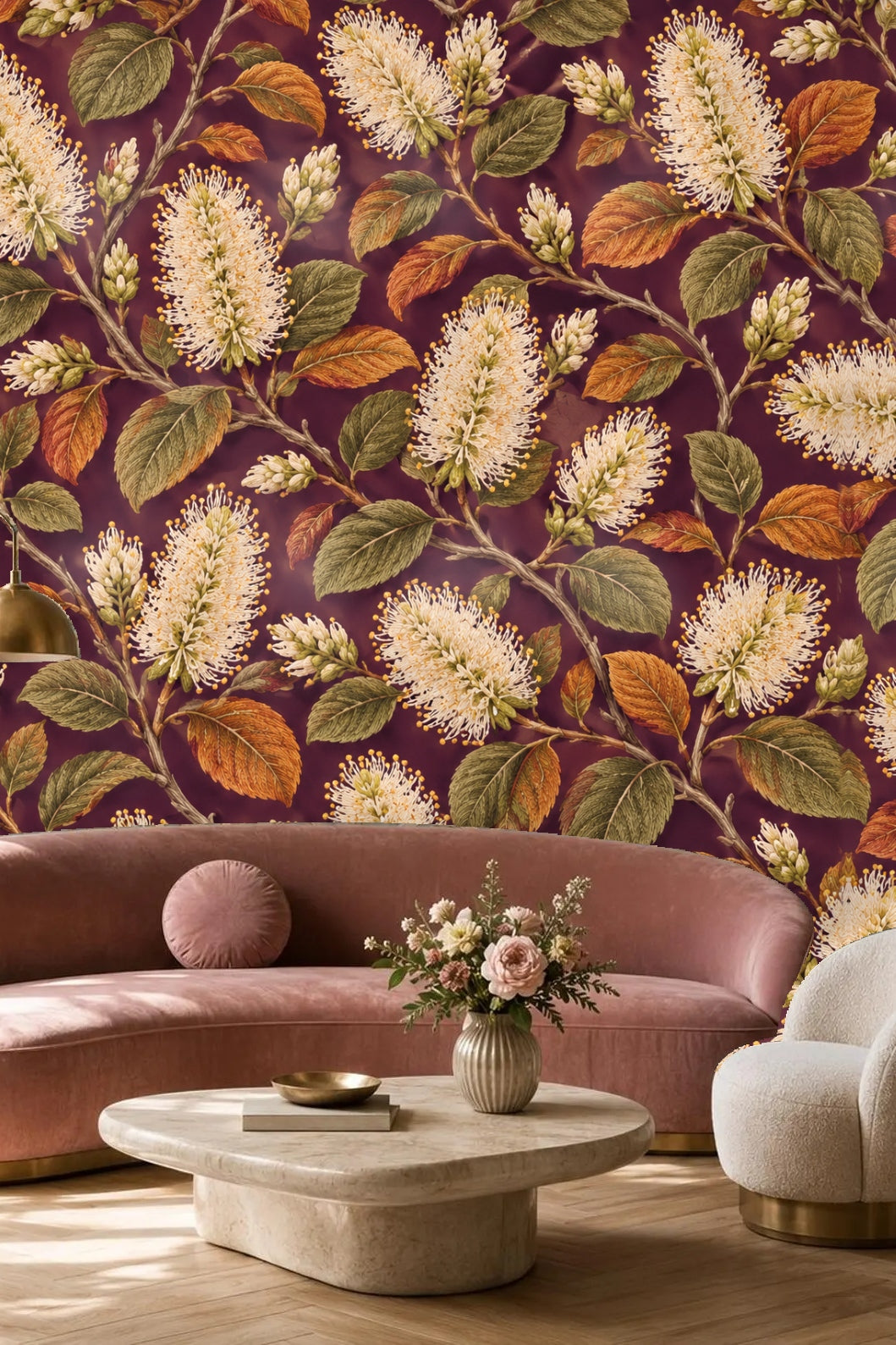 Living room with a bold wallpaper of ivory bottlebrush flowers and autumnal leaves on plum behind an orange sofa and mid-century style decor