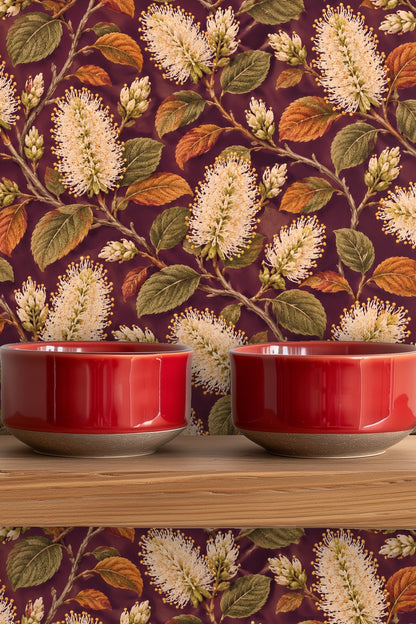 Floral pattern with ivory bottlebrush flowers and warm rust and olive leaves on deep plum backdrop