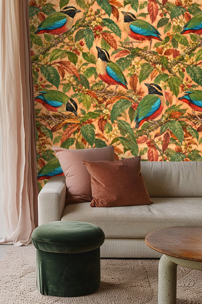 Bird and foliage wallpaper seen in a cozy seating area with navy and orange accents.