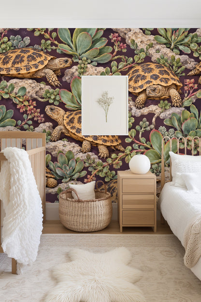 Living room scene with blush chair against wallpaper of pancake tortoises and succulents on dark plum background.