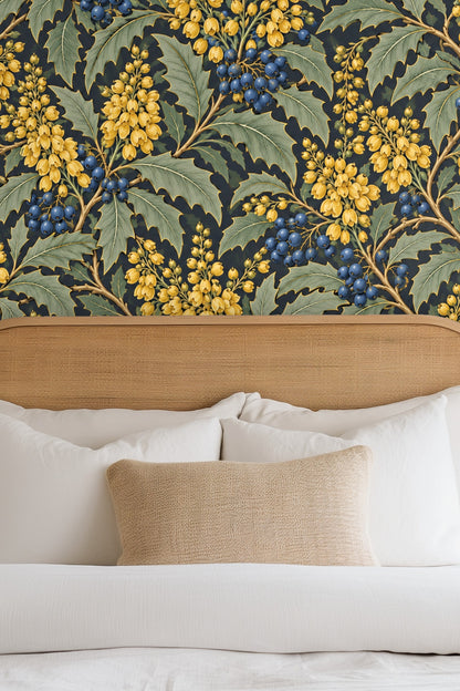 Side view of a sofa set against mahonia botanical wallpaper with warm lighting