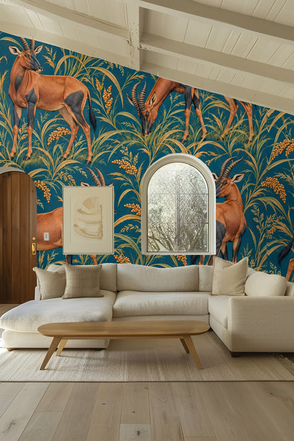 Room shot showing Topi in Petrol Fields wallpaper behind a bedside with lamp and neutral bedding