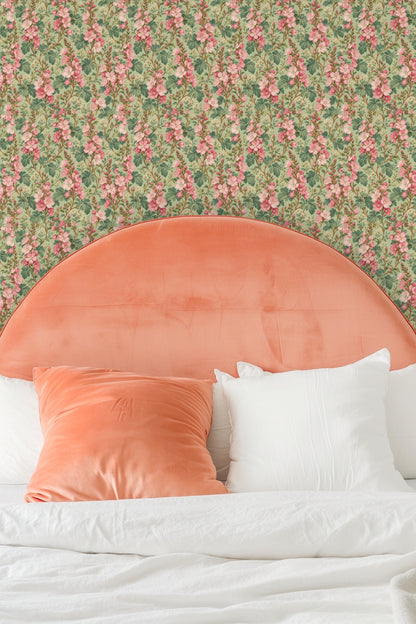 Wallpaper pattern with pink floral columns displayed behind cream pillows on a beige couch