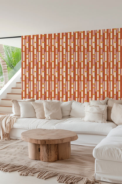 Styled living area with patterned wallpaper in warm terracotta tones behind neutral furniture.