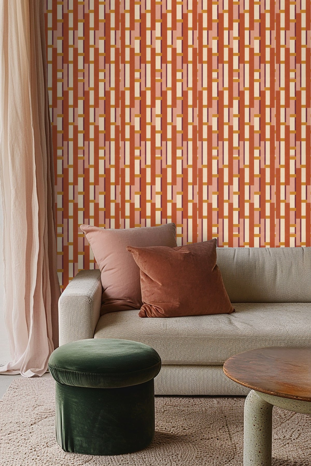 Soft pink pillows complementing warm terracotta and cream wallpaper behind a bed.