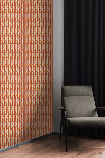 Neutral sofa positioned in front of warm-toned geometric wallpaper mural.