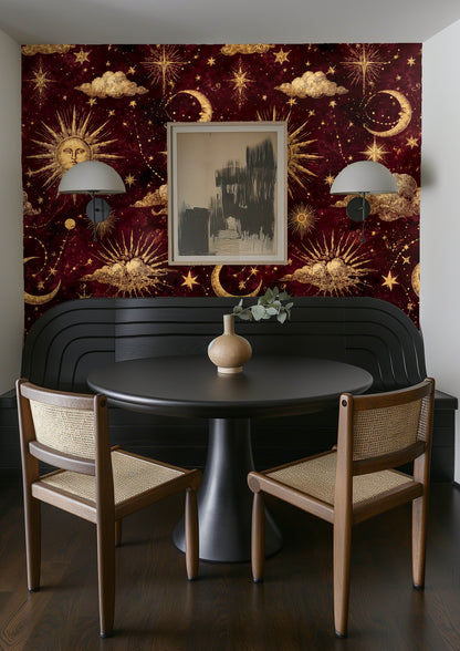 Gallery wall above crib with framed prints layered over the gilded star-and-cloud wallpaper repeat