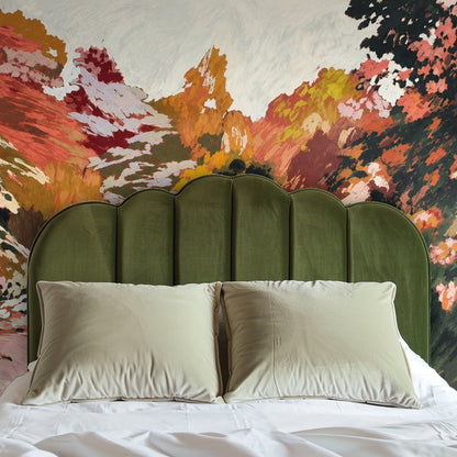 Arched niche with round mirror framing the mural, painterly foliage and reflective pool visible within a plaster alcove