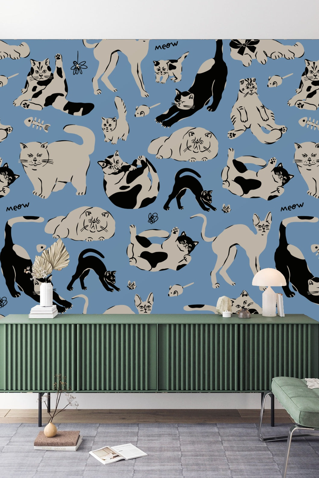 Kitchen interior featuring whimsical cat-themed blue wallpaper behind blue glass cabinet