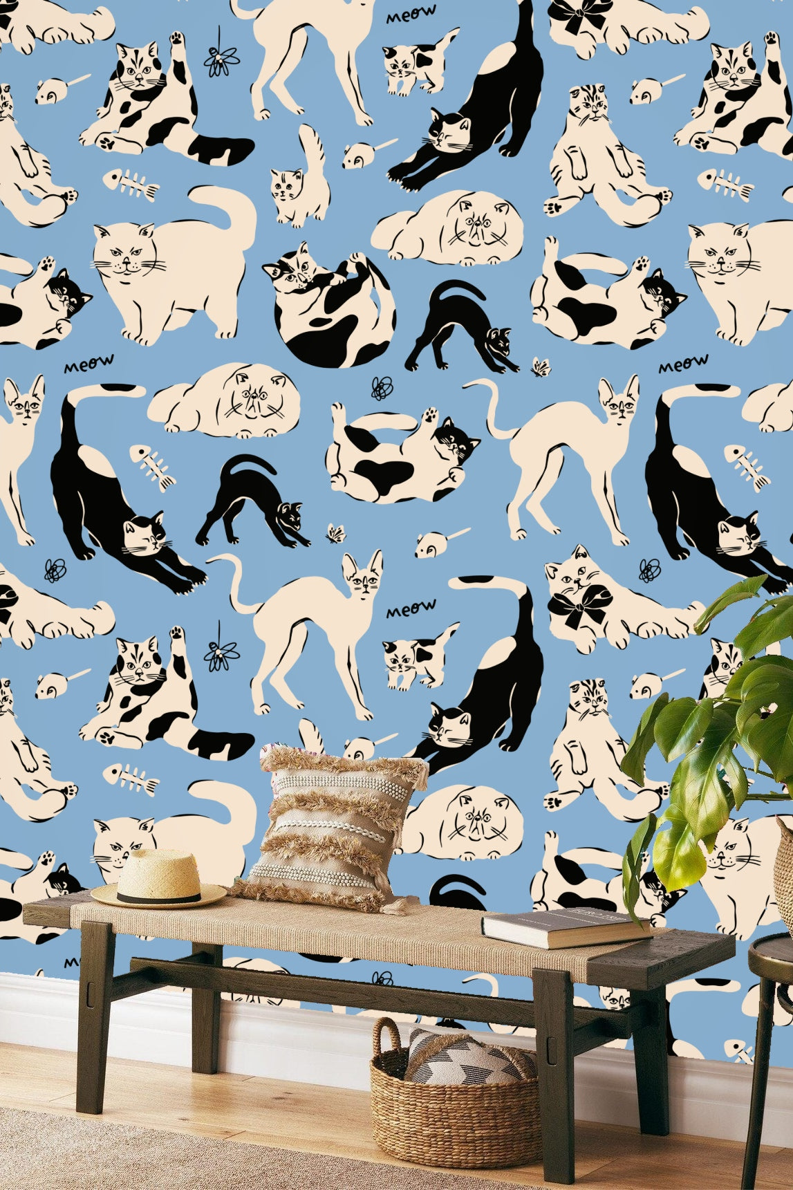Living room wall adorned with blue wallpaper patterned with black and cream cats, mauve sofa in foreground