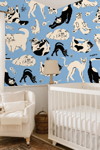 Whimsical cat wallpaper pattern shown behind mauve sofa with pillows