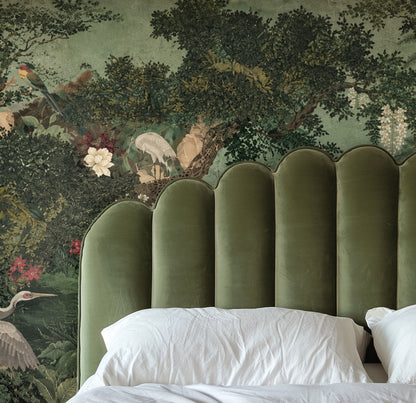 Living room feature wall with Verdant Court mural behind a charcoal sectional and coral accent chair demonstrating scale and contrast.