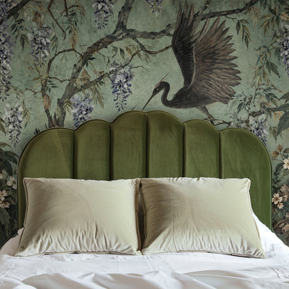 Arched niche vignette with a circular mirror, the mural cropped to reveal a crane wing and trailing wisteria.