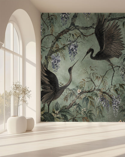 Nursery view with a white vintage crib set against the mural, cranes and cream blossoms forming a storybook backdrop.