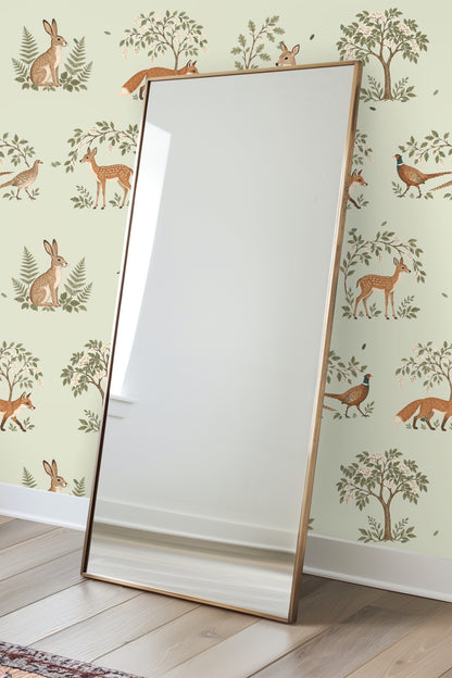 Close-up view of the sleeping fawn beneath leafy branches on the wallpaper.