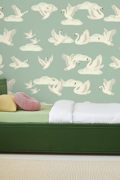 Pattern repeat detail of Celestial Swans Wallpaper showing swans and clouds on sage green background