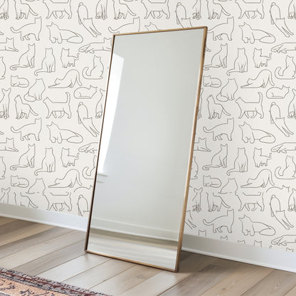 Nursery scene with a wooden crib positioned against the cat outline wallpaper repeat