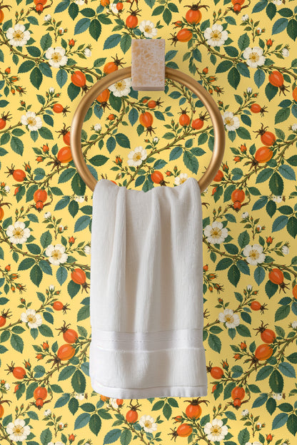Decorative ladder with beige throw in front of rosehip patterned wallpaper