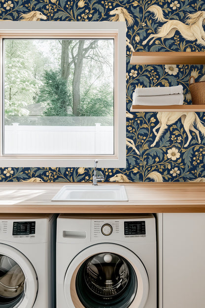 Close-up of deep blue floral wallpaper with cream Saluki dogs behind a blue velvet sofa