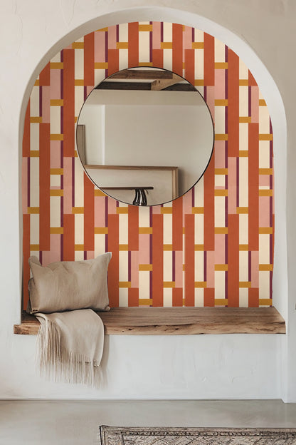 Close-up of leather chair against terracotta and rose geometric wallpaper with clean vertical lines