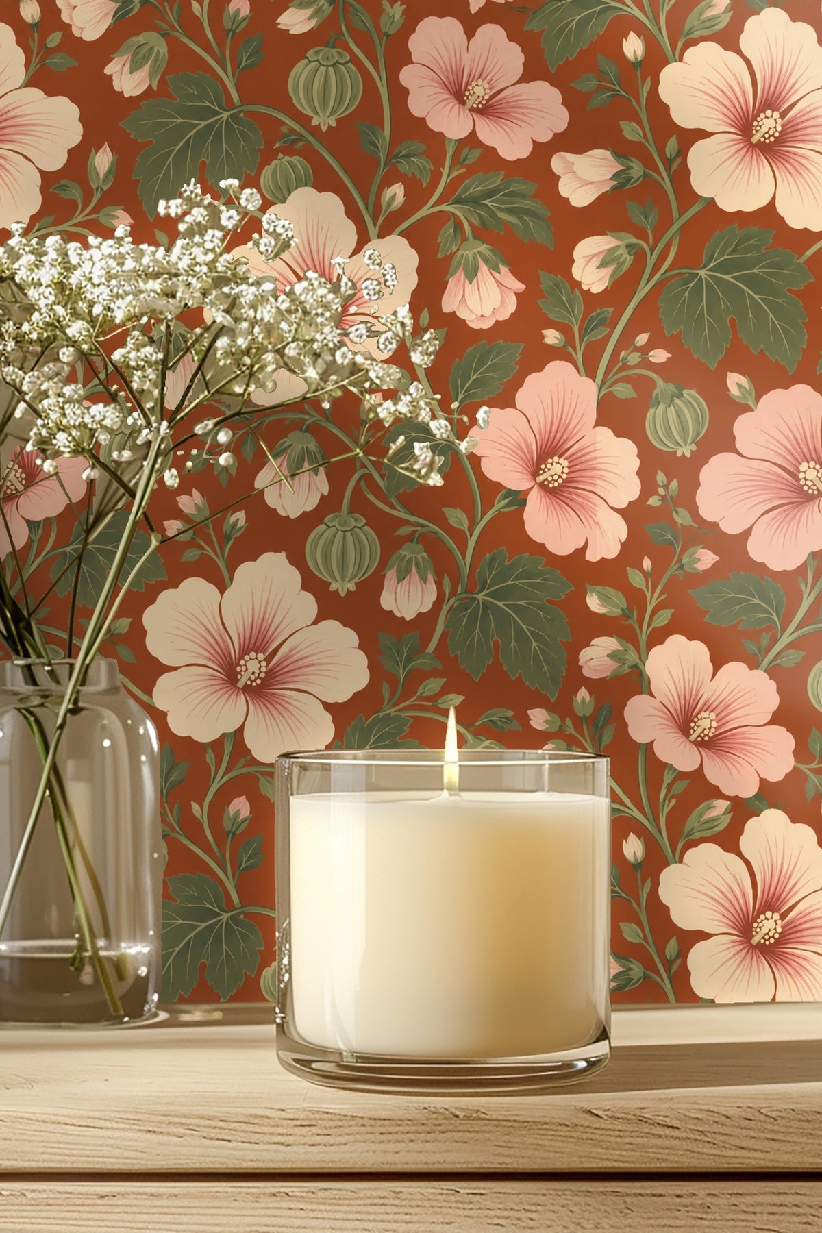 Wallpaper detail behind glass candle and baby's breath flowers showing blush hibiscus and sage green leaves