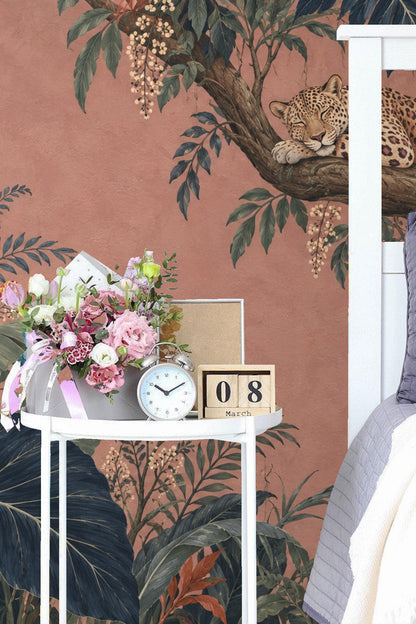 Antique console table with floral arrangements and candlesticks set against Dusk Leopard Grove wallpaper featuring a reclining leopard