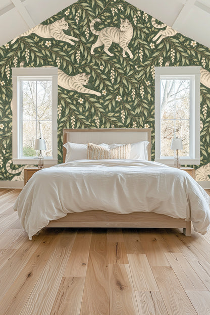 Wall-mounted towel ring with brass finish in front of wallpaper with cats and leaves.