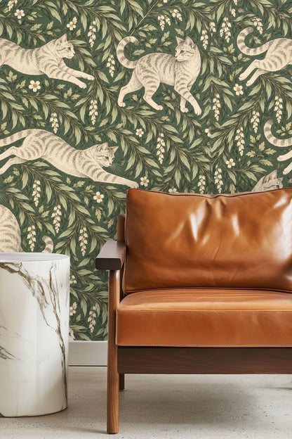 Bedroom with green botanical wallpaper featuring playful tabby cats, wood furniture, and warm textiles.