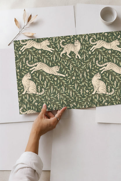 Leaping tabby cat with outstretched legs woven into green leaf pattern.