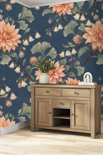 Dusky dahlia floral wallpaper pattern on deep blue background with coral orange blooms and green leaves.