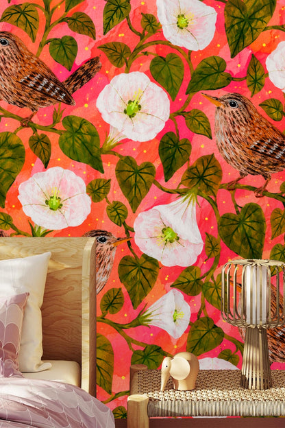 Wallpaper shown in a living room setting with mauve sofa, illustrating scale of detailed wrens and moonflowers on coral background.