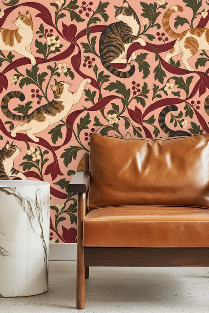Living room close-up of wallpaper showing detailed tabby cats and burgundy ribbons behind a caramel leather chair and marble side table.