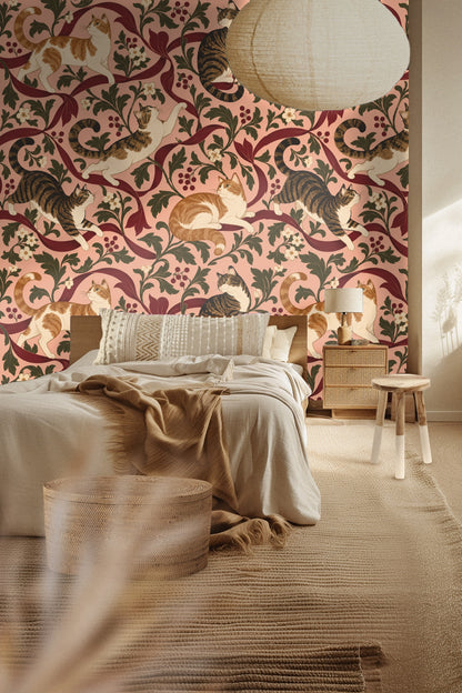 Section of wallpaper showing a curious tabby cat pawing at a crimson ribbon amid green botanical leaves and white flowers.